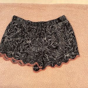 Black and white print shorts with pink accent on bottom. 100 percent rayon.